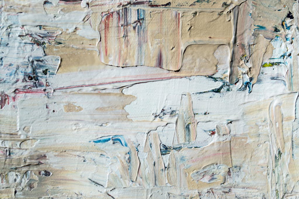 Close-up of textured abstract painting with layered acrylic paint in neutral tones.